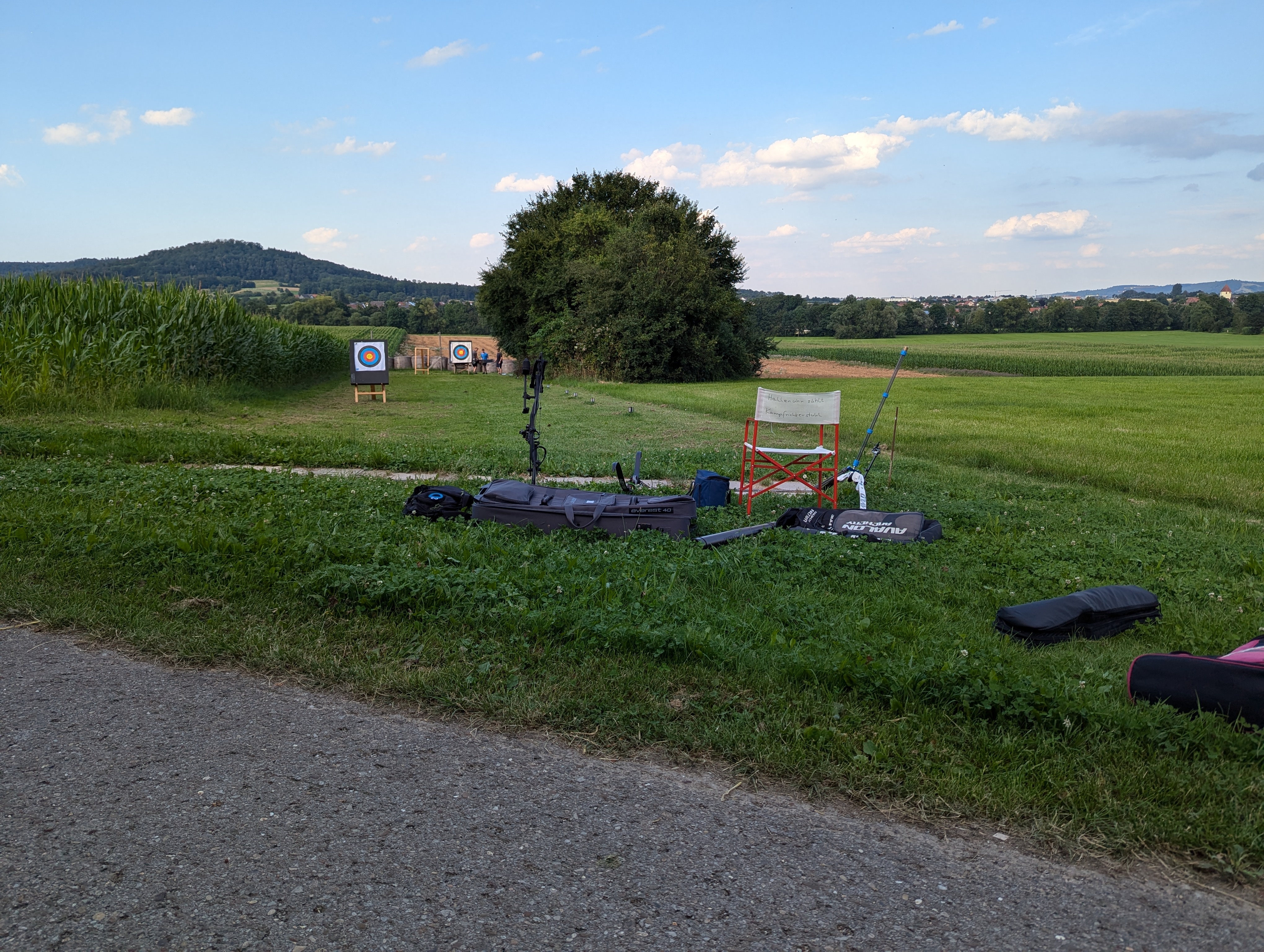 An archery range in a rural area with equipment and targets.