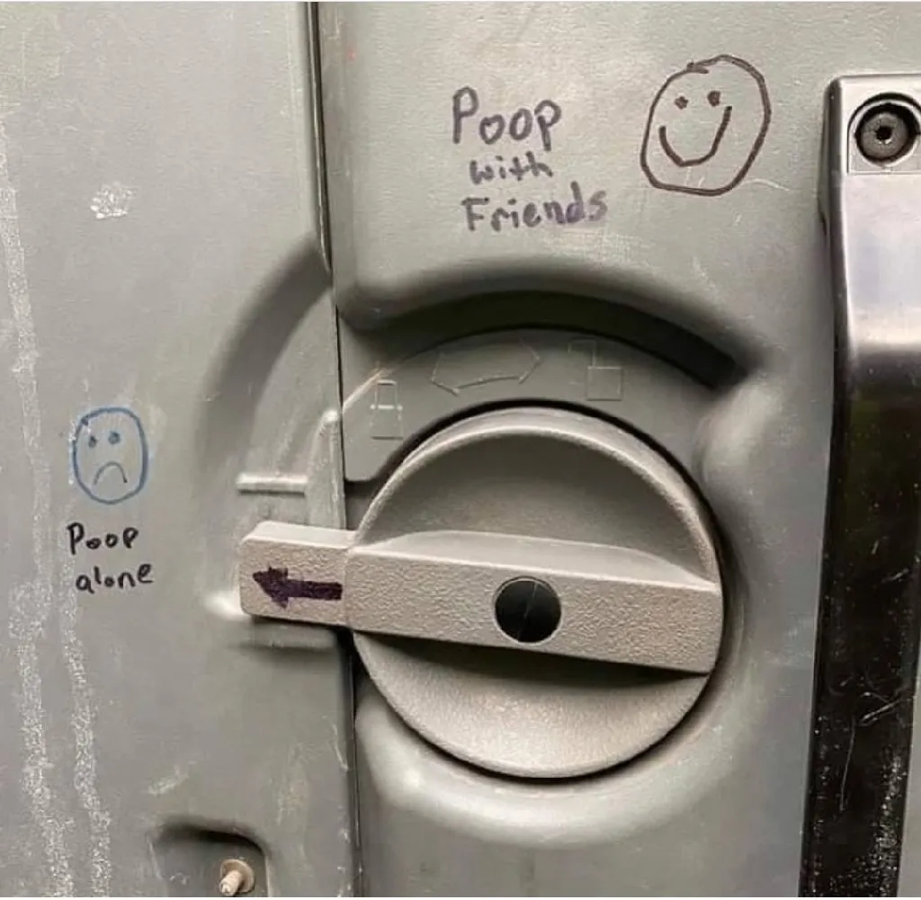 Image of a toilet stall door lock. When it is locked, it points to writing saying 'poop alone [sad face]'  and when it is unlocked, it points to writing saying 'poop with friends [happy face]'